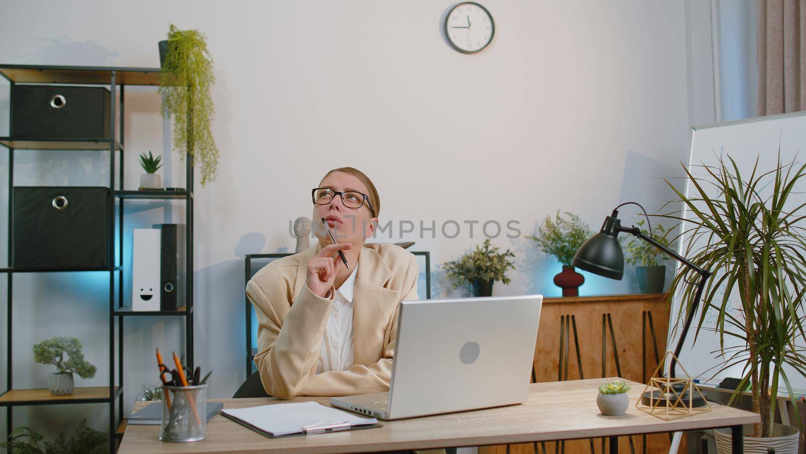 Businesswoman freelancer enters office workplace, working on laptop computer at desk. Professional manager freelancer woman works on notebook, sends messages makes online purchases watching movies