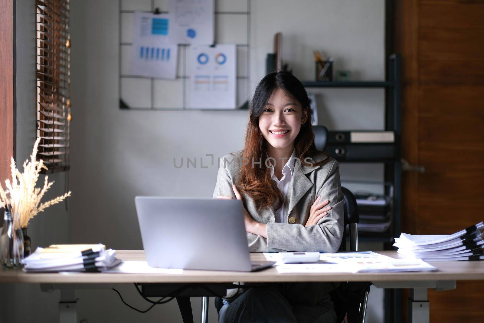 business Asian woman working online at home office and looking at the camera..