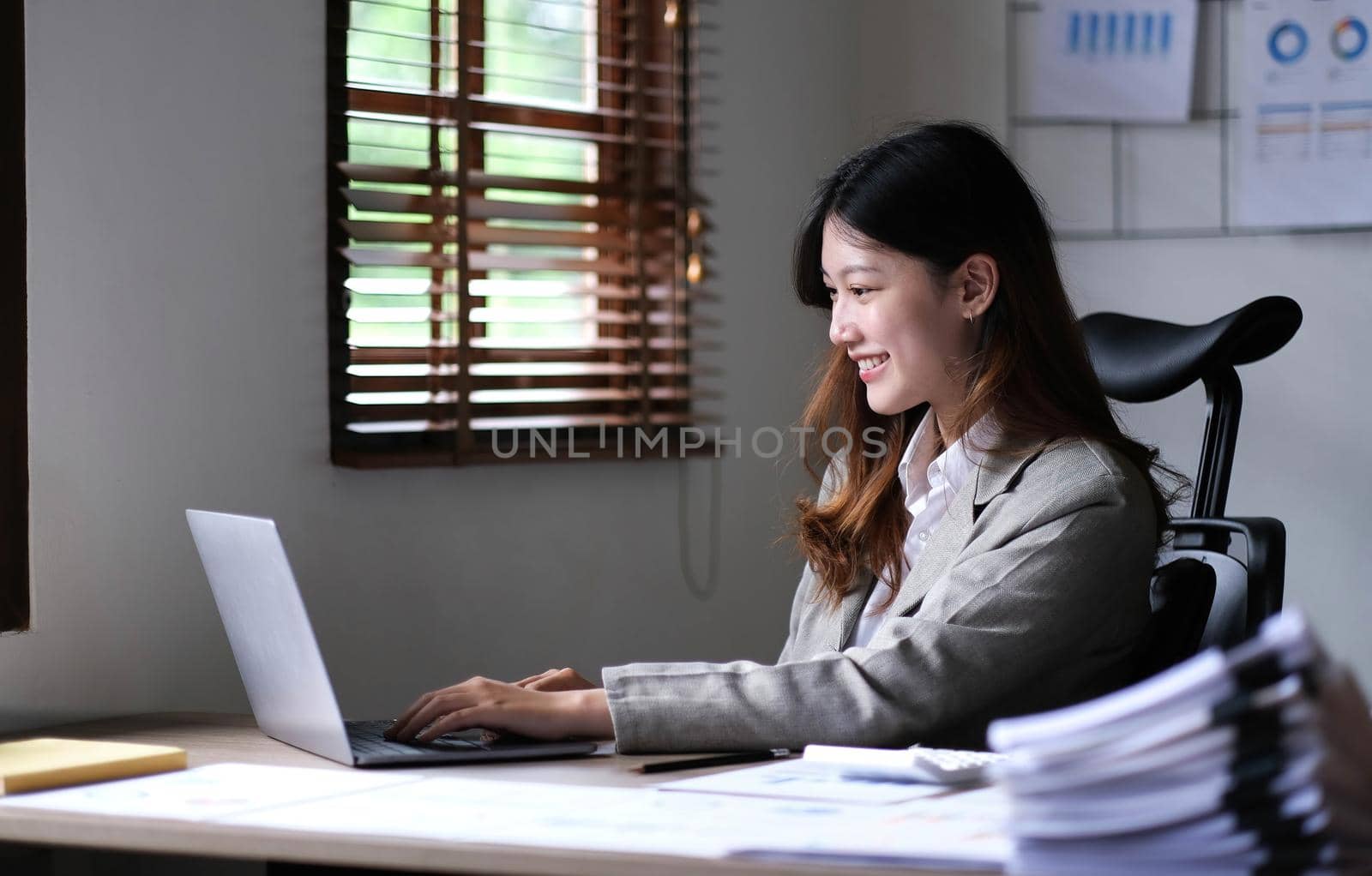 Portrait of smiling beautiful business asian woman working in office use computer with copy space. Business owner people sme freelance online marketing e-commerce telemarketing, work from home concept.