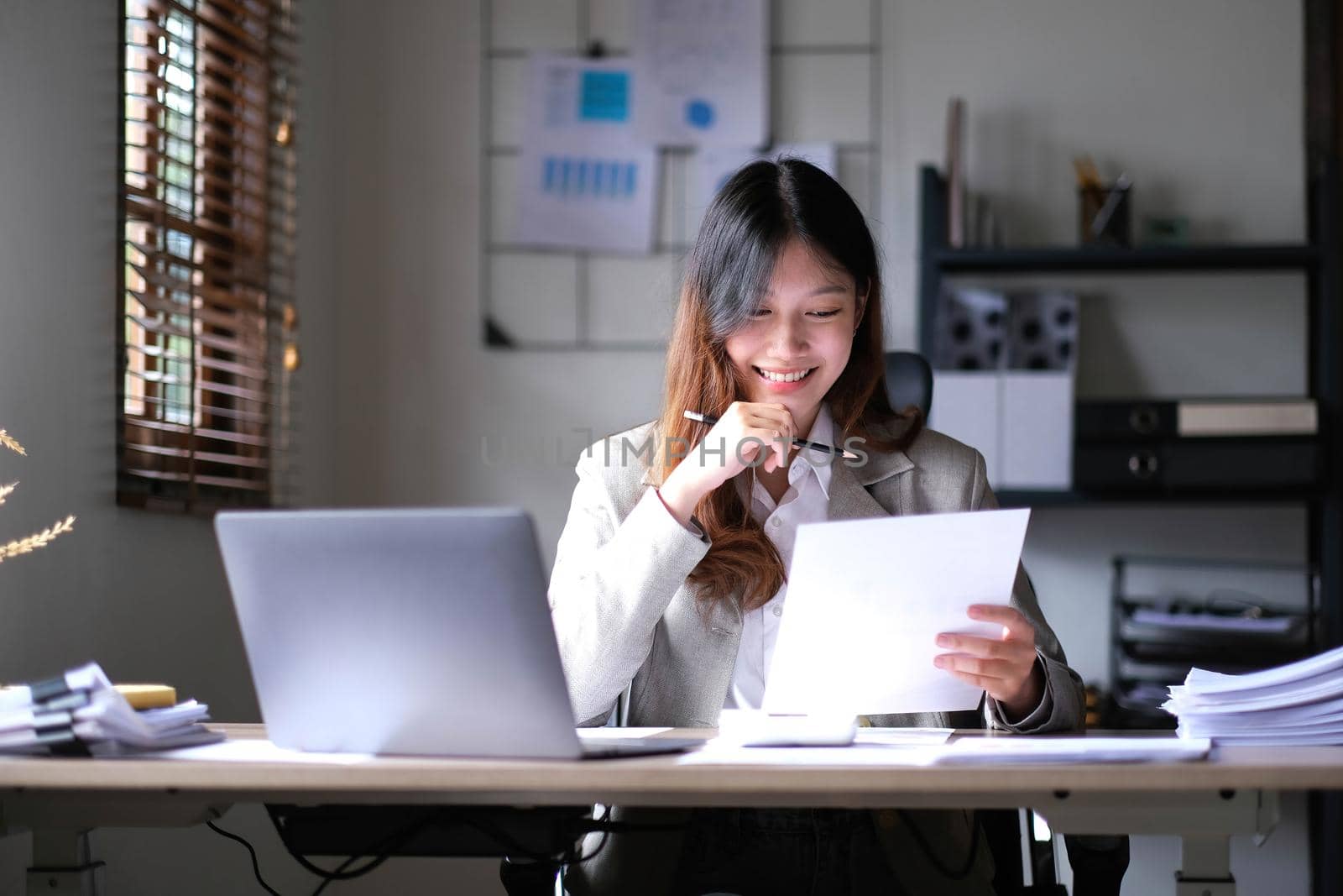 Beautiful young asian woman sitting at coffee shop using laptop. Happy young businesswoman sitting at table in cafe with tab top computer..