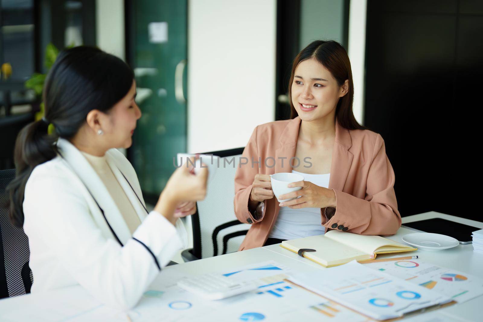 female marketing and sales employee talking and taking a coffee break. by Manastrong