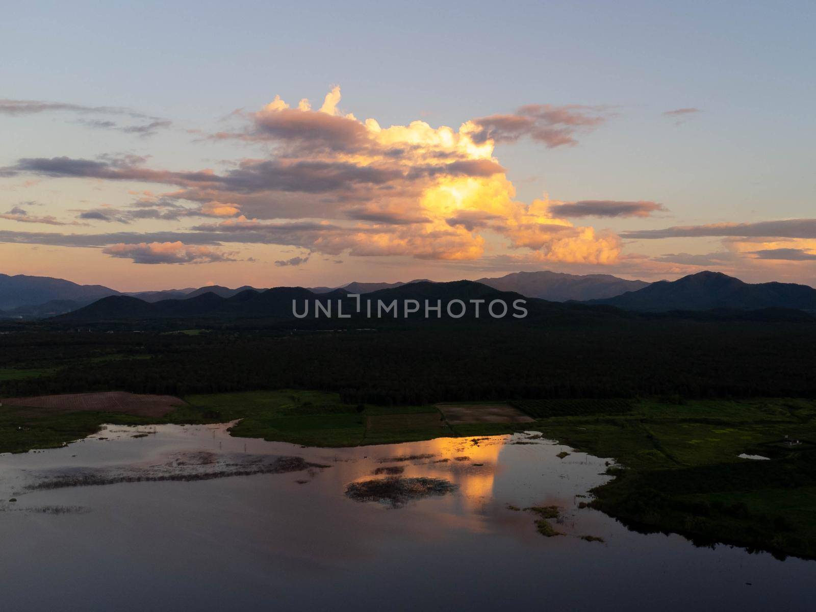Aerial view of agricultural area by reservoir on tropical mountain background at sunset in northern Thailand. Beautiful landscape nature background. by TEERASAK