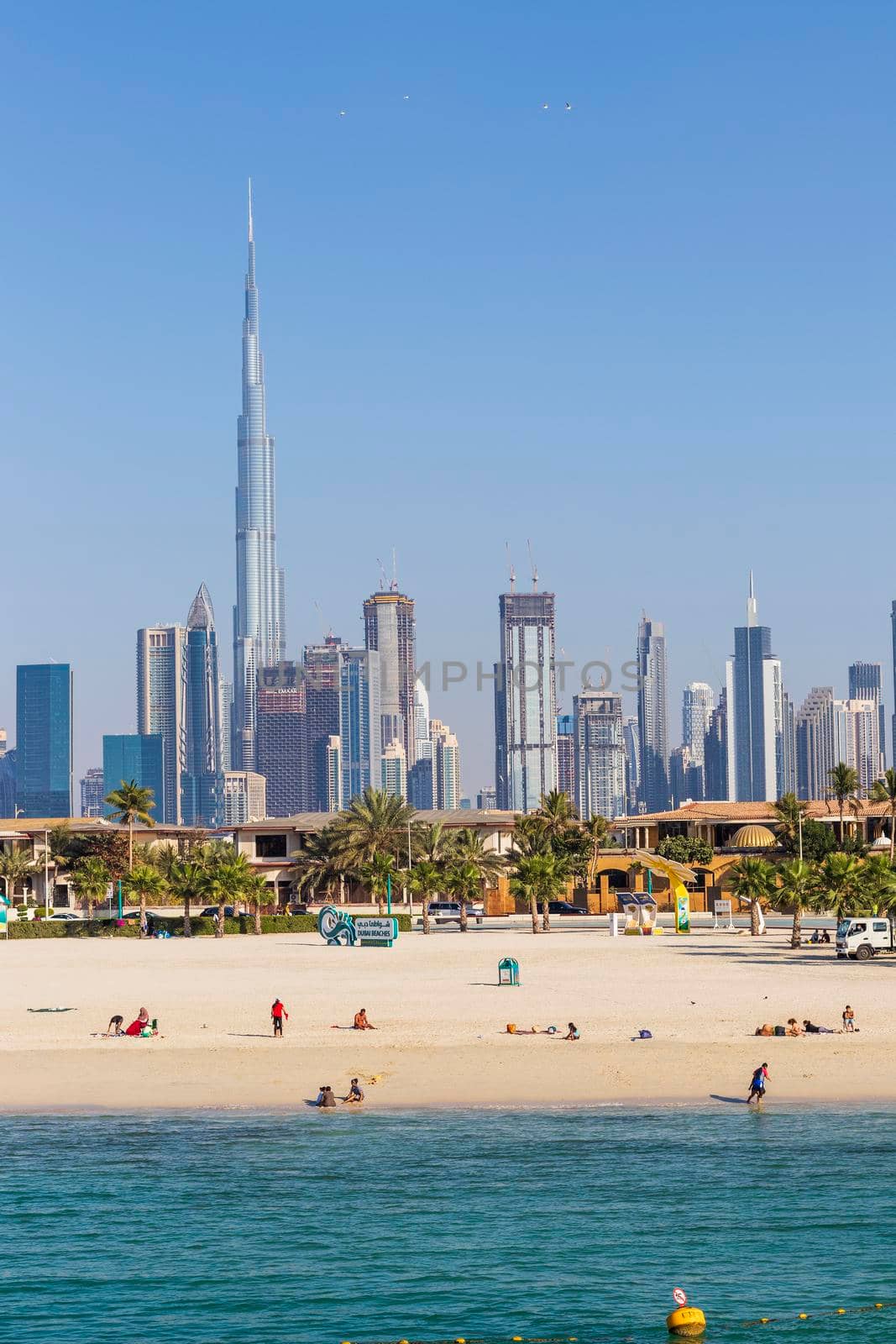 Dubai, UAE - 02.27.2021 Dubai public beach with city skyline on background. Outdoors by pazemin