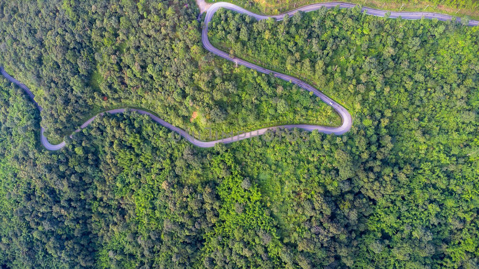 Aerial view of a hilltop road with beautiful green forests in Thailand. Aerial capture with drone. by TEERASAK