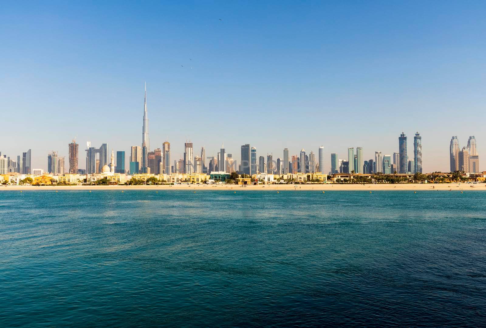 Dubai, UAE - 02.27.2021 Dubai public beach with city skyline on background.