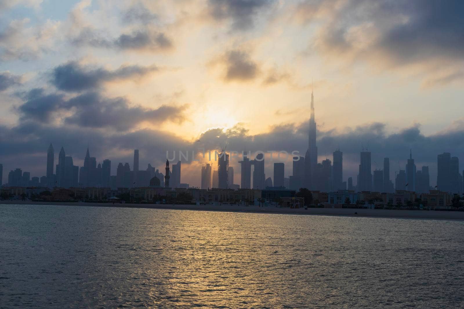 Dubai, UAE - 03.06.2021 Dubai public beach with city skyline on background.Sunrise hour. Outdoor by pazemin