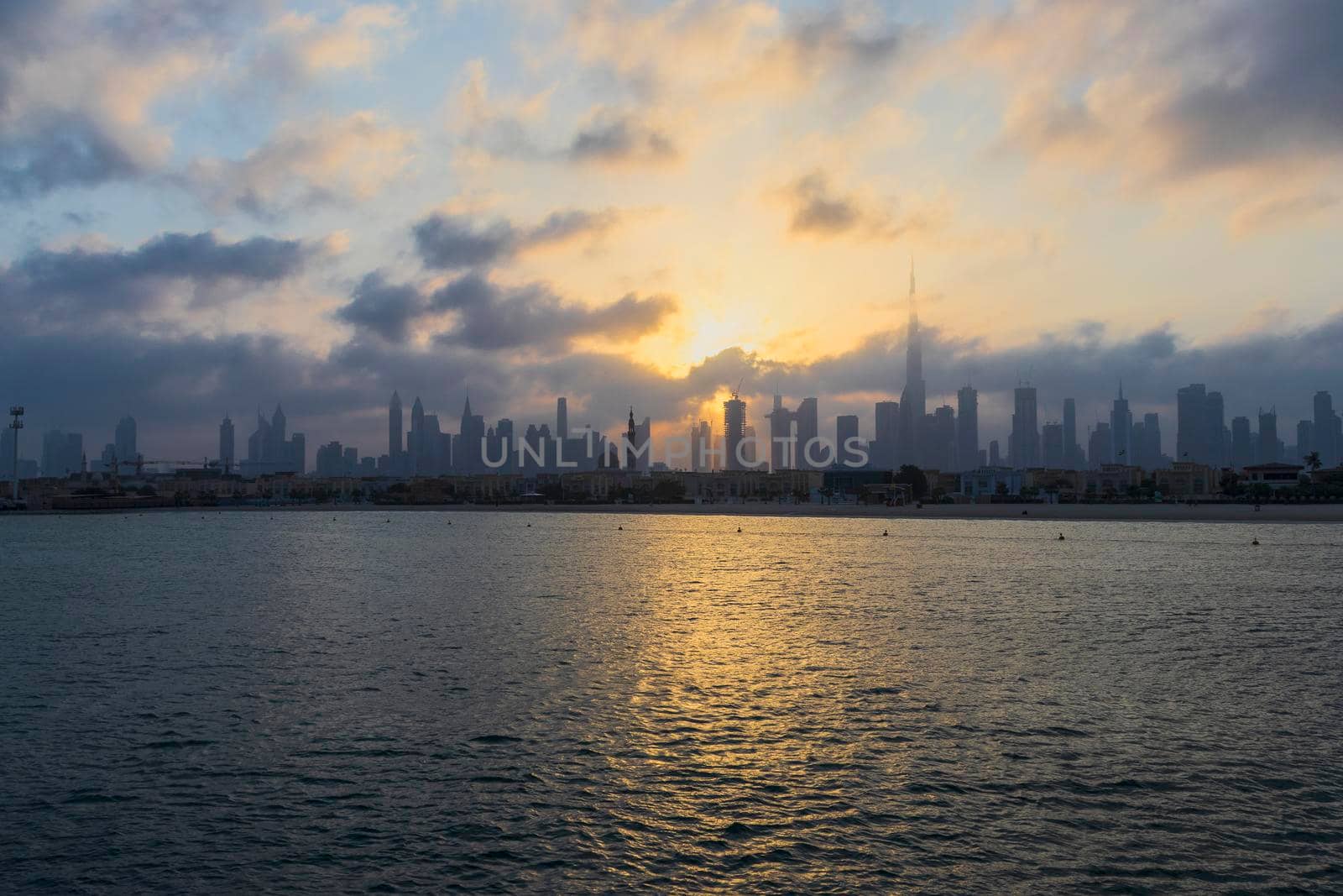 Dubai, UAE - 03.06.2021 Dubai public beach with city skyline on background.Sunrise hour. Outdoor by pazemin