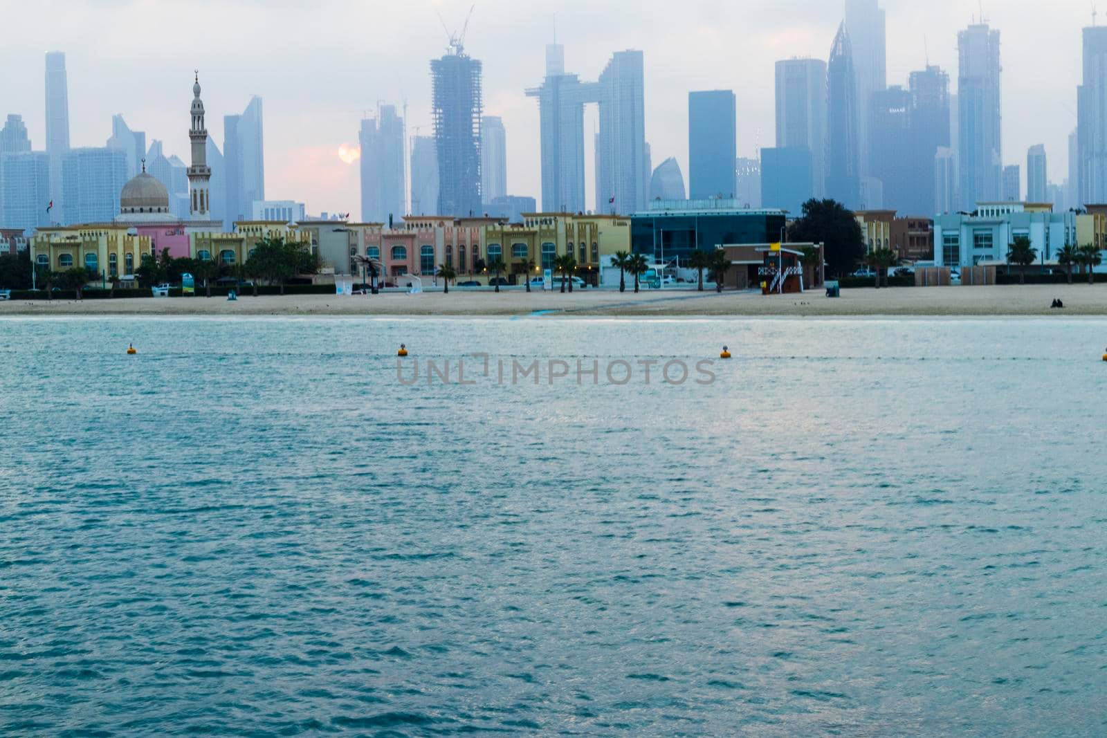 Dubai, UAE - 03.06.2021 Dubai public beach with city skyline on background.Sunrise hour. Outdoor by pazemin