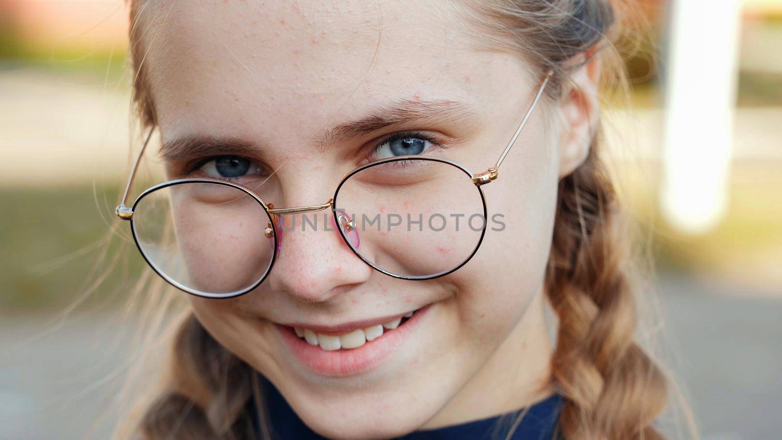 A teenage girl wearing glasses. Close-up of her face