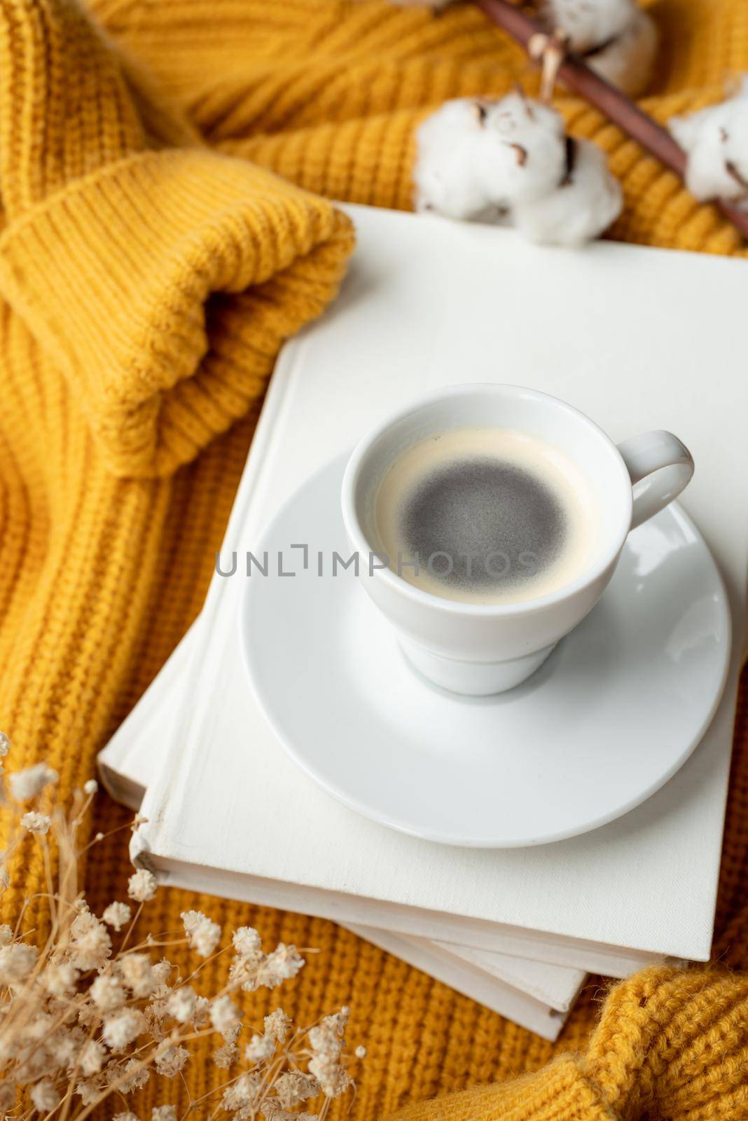 cozy composition of warm yellow sweater, white books , cup of hot coffee and dry flowers , top view by Desperada