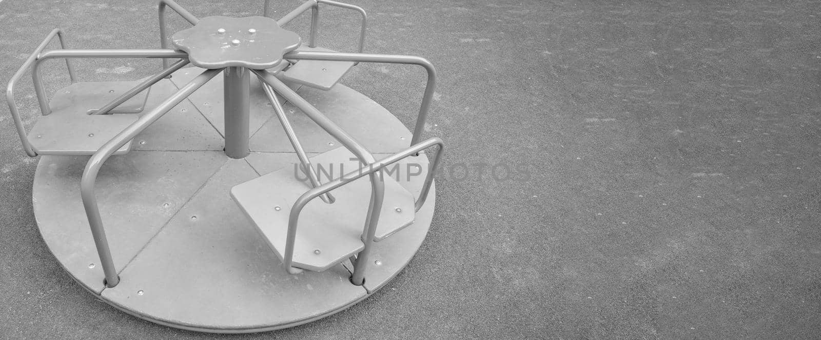 Steel round carousel on the playground, copy of the space on the right, monochrome by claire_lucia