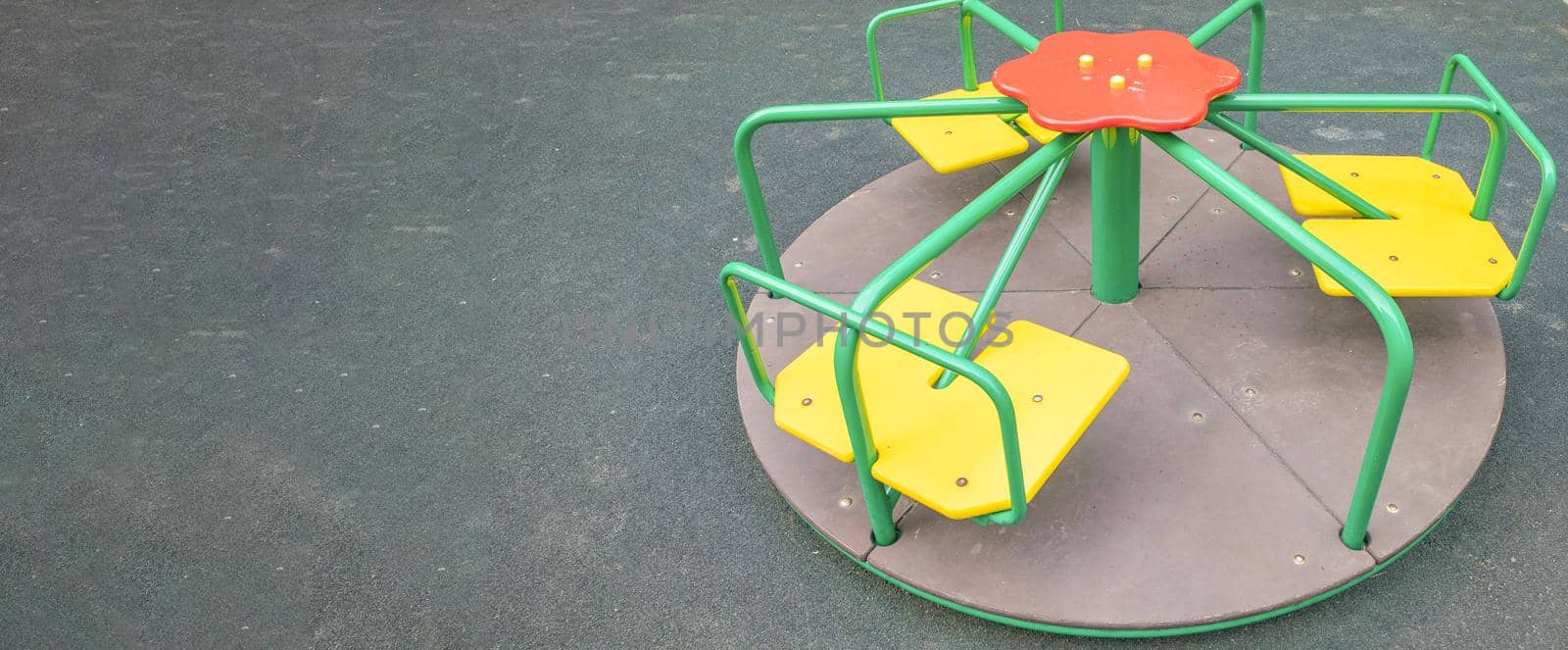 Multi-colored steel round carousel on the playground, a copy of the space on the left.