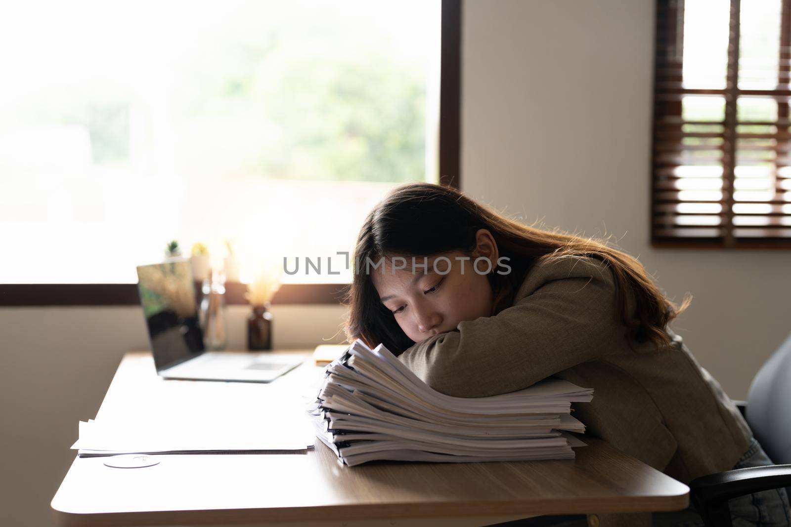 Tired business asian woman feel exhausted and stressed with stack of financial documents