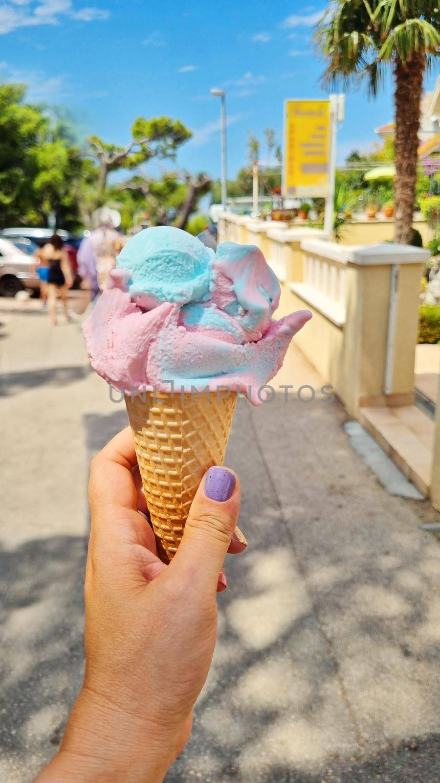Gelato ice cream cone held up to the hot summer city.