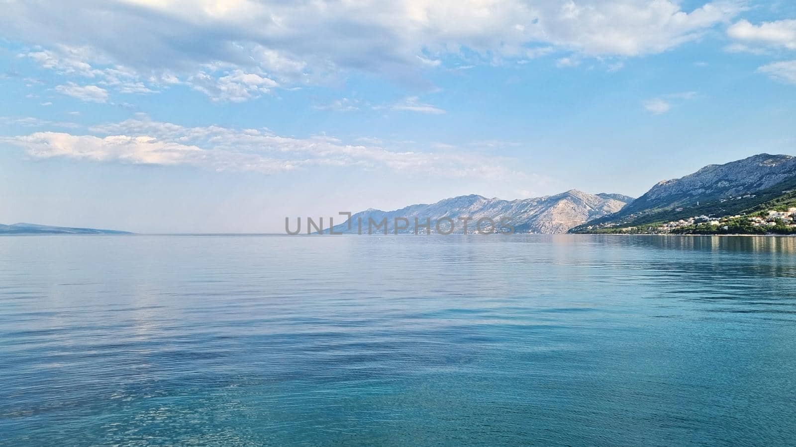 Beautiful shore of the Adriatic Sea. Bay view with cloudscape. Sunrise.