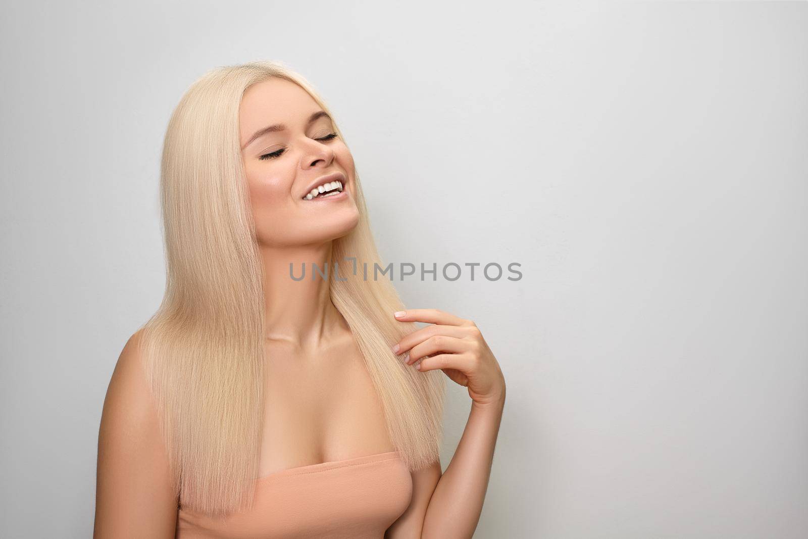 Beautiful woman with magnificent Blond Hair. Happy Model with Shiny Long Healthy Hairstyle. Keratin Treatment, Hair Lamination, Hair Botox and Brazilian Blowout. Beauty and haircare