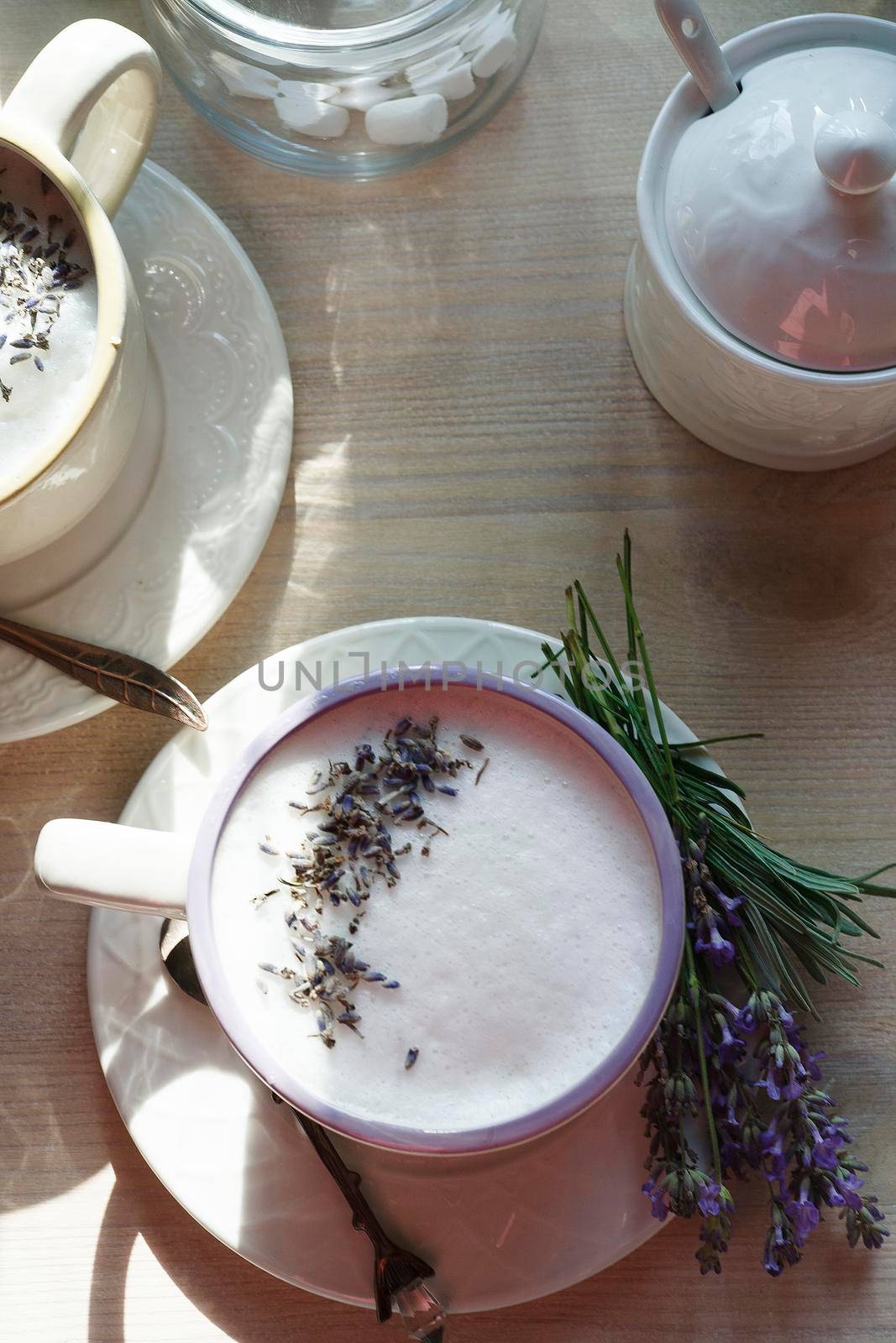 A cup of home made earl grey tea latte drink with lavender flower buds in white cups with fresh lavanda flowers on white table, good morning concept, selective focus., flat lay.