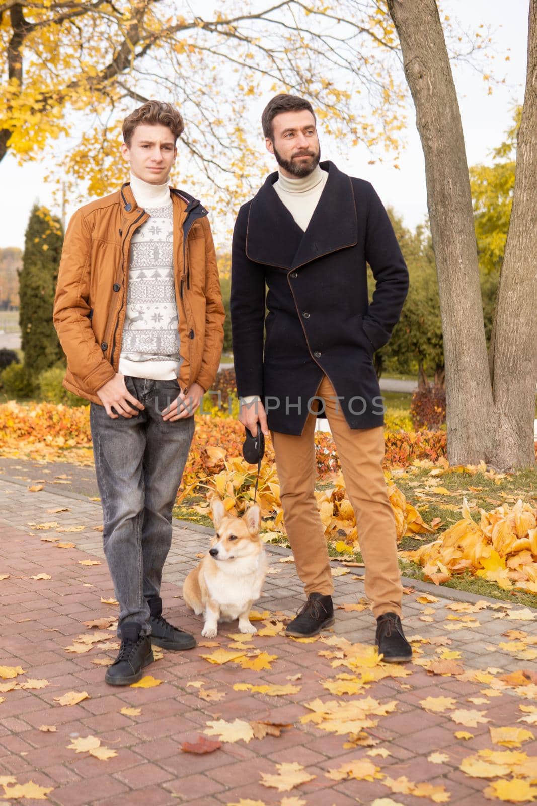 Father and son with a pet on a walk in the autumn park by Annu1tochka