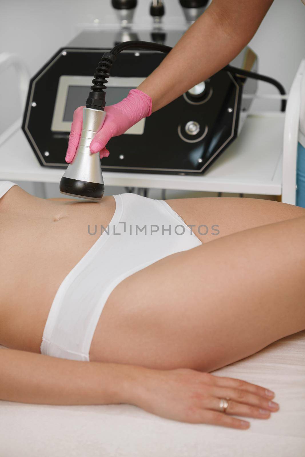 Vertical cropped shot of a woman getting cellulite reduction treatment at cosmetology clinic