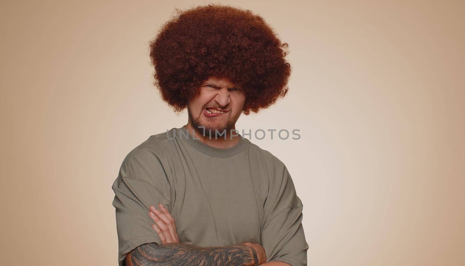 Dissatisfied man shaking head no, asking reason of failure, expressing disbelief irritation, feeling bored, disappointed in result, bad news. Adult guy isolated alone on beige studio wall background