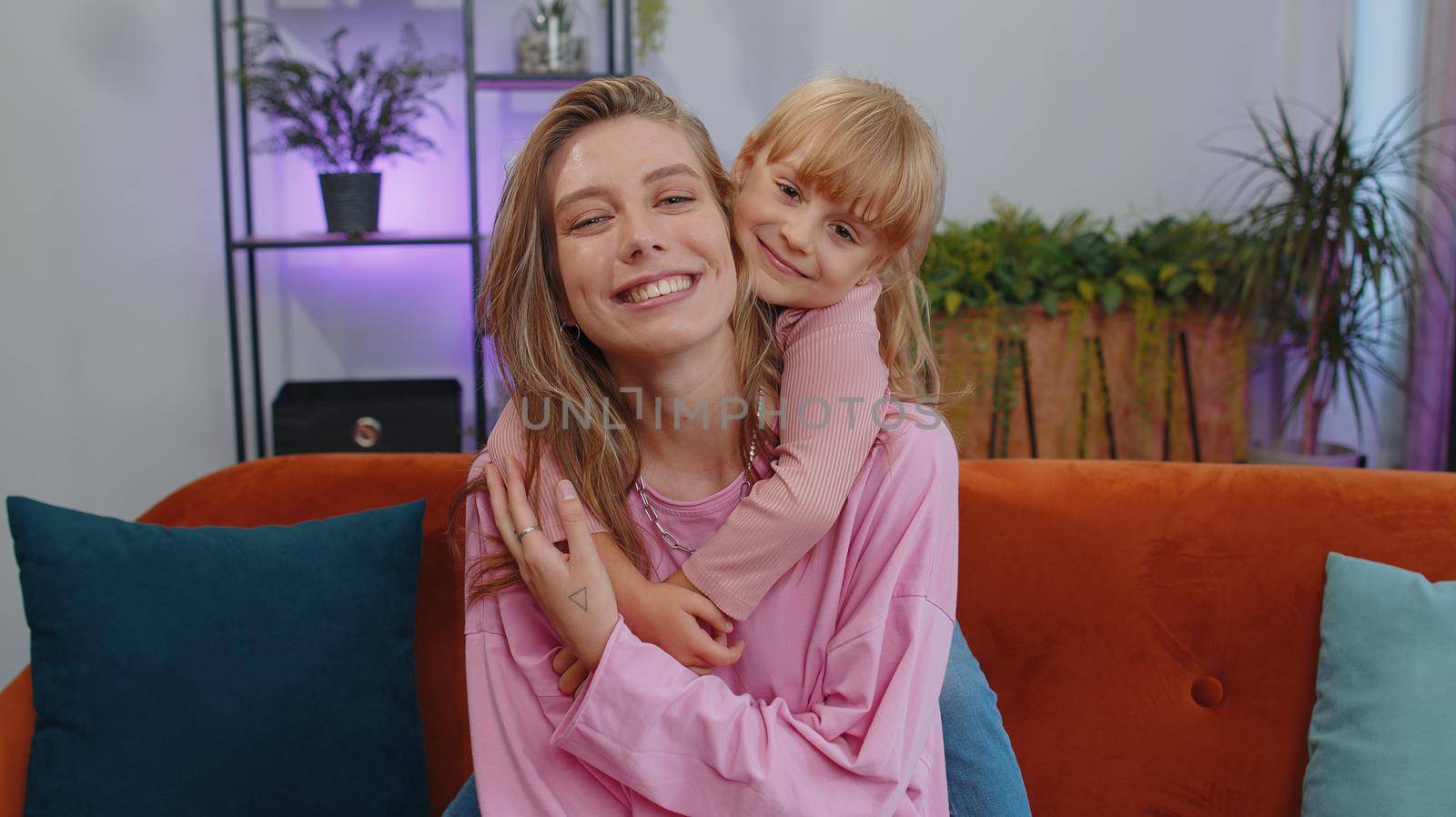 Pretty smiling cute child kid daughter embrace mom look at camera. Happy beautiful family young adult single mother foster nanny parent and toddler girl hug enjoy sweet tender love. Close-up portrait