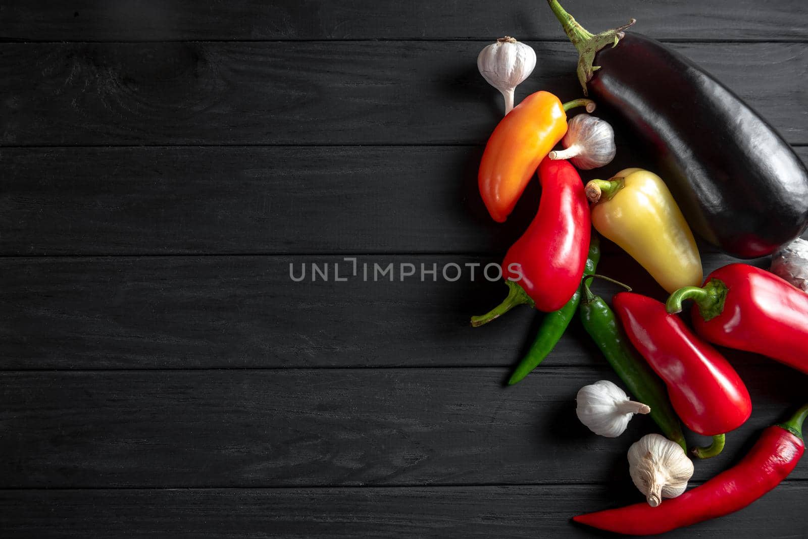 Vegetables on a black wooden background for a traditional Balkan dish called Ajvar. Copy space