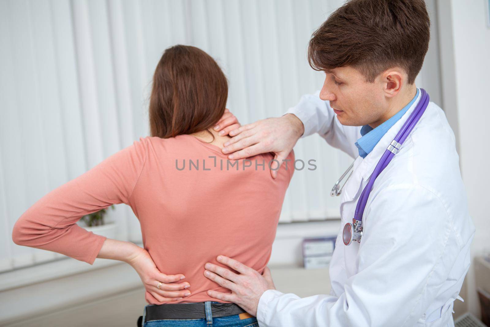 Female patient with back pain being examined by doctor