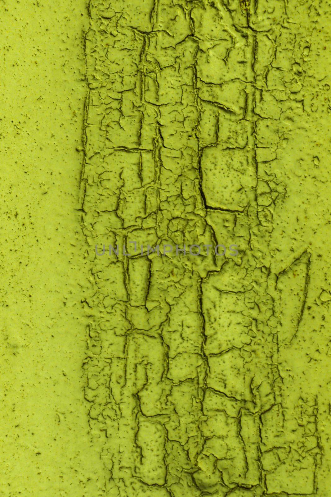 Texture of peeling paint on the wall. The surface of an old pastel green paint that is cracked.