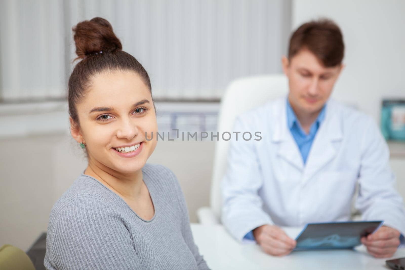 Close up of a happy healthy young woman smiling to the camera after medical appointment with her doctor at the hospital