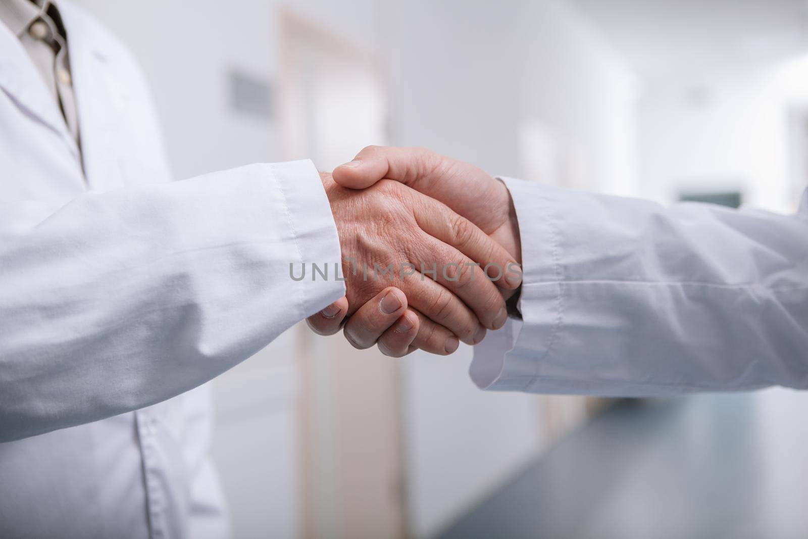 Cropped close up of two male doctors shaking hands