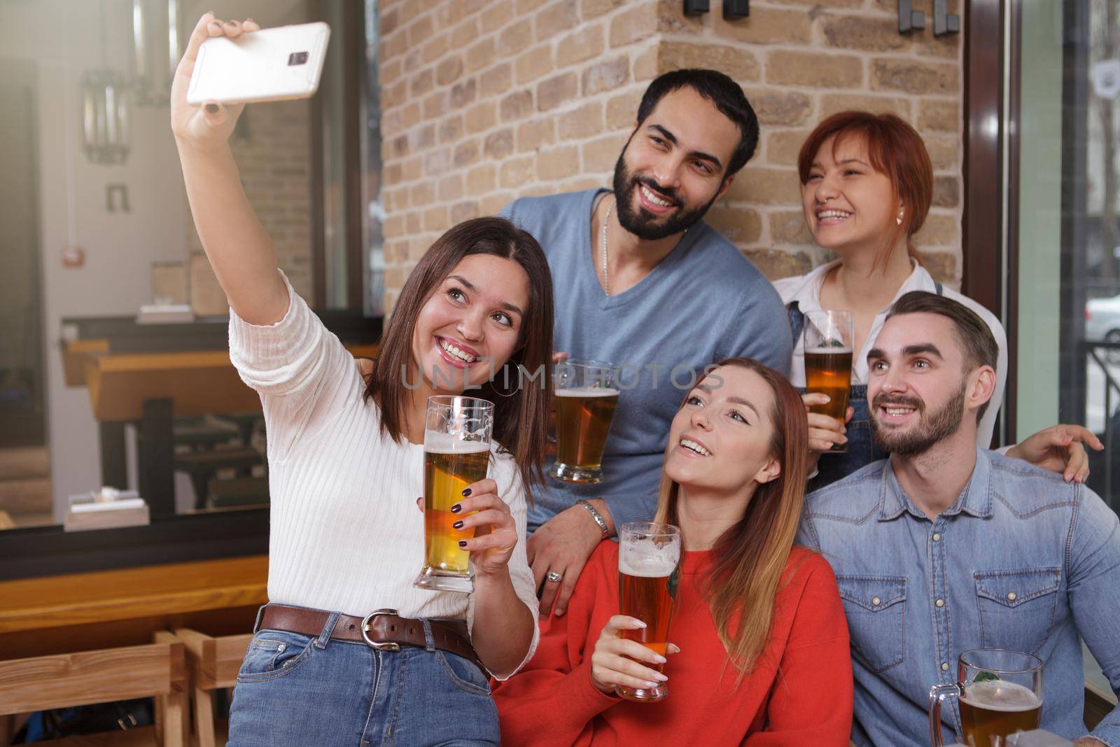 Group of friends drinking beer at the pub together by MAD_Production