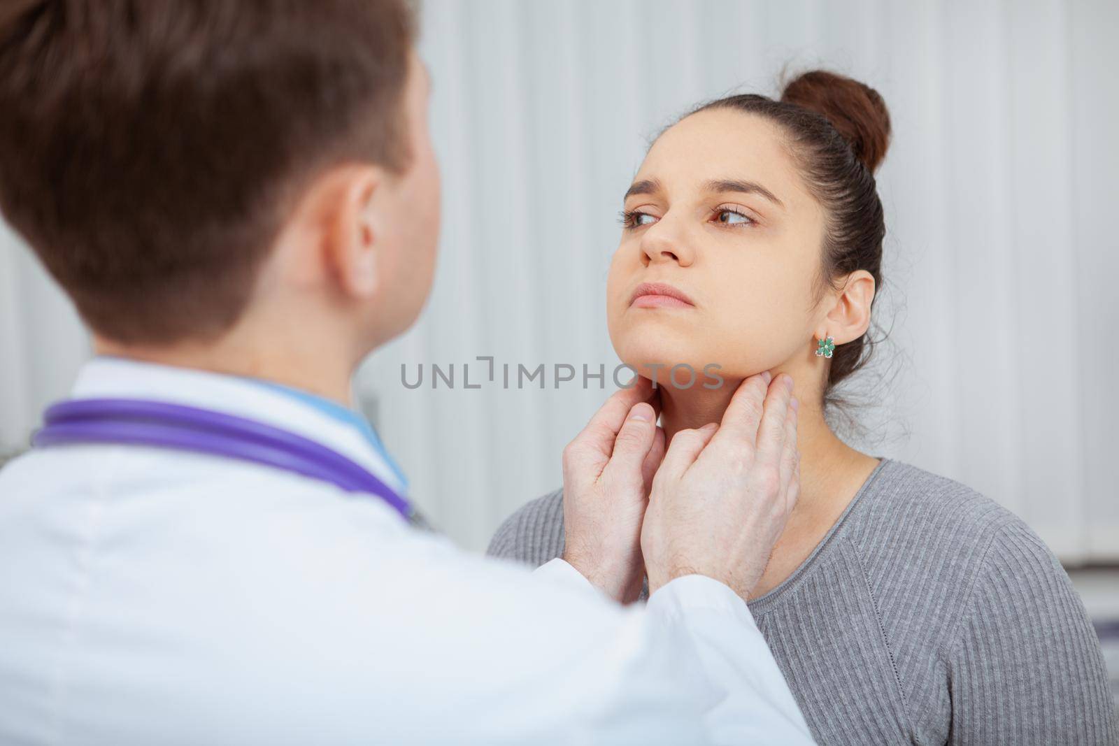 Cropped shot of a young women having her neck and throat examined by doctor at the hospital. Virus, flu, sore throat concept