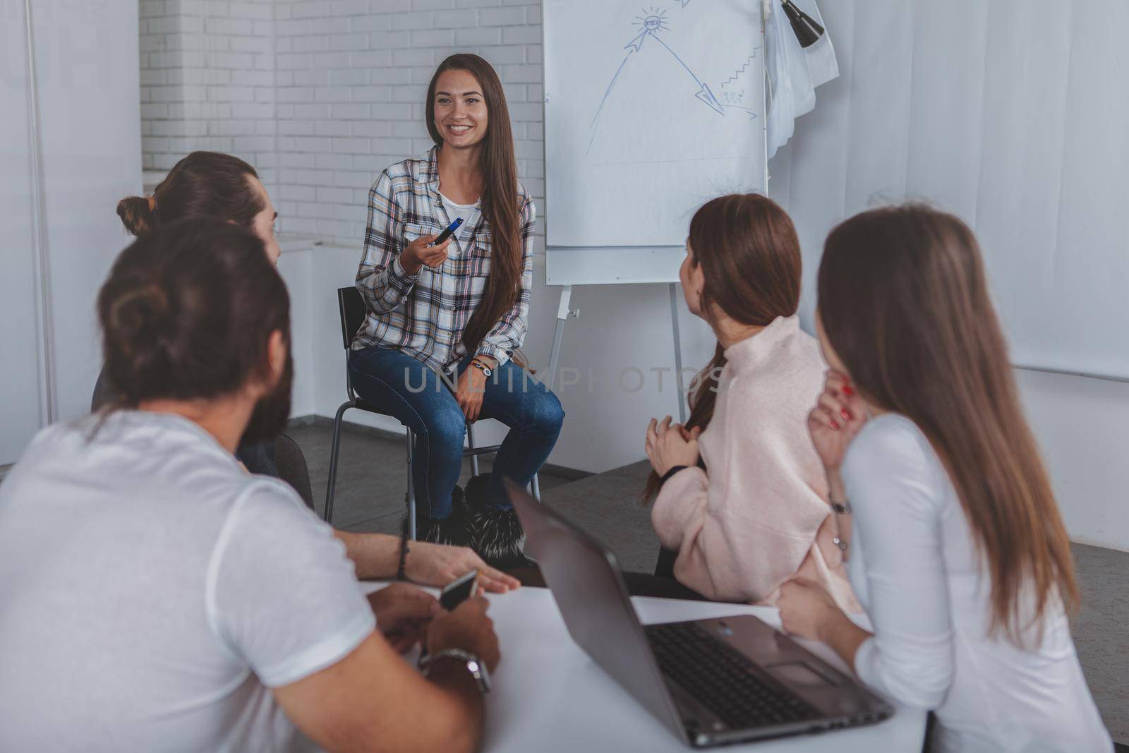 Beautiful young businesswoman leading meeting at the office by MAD_Production