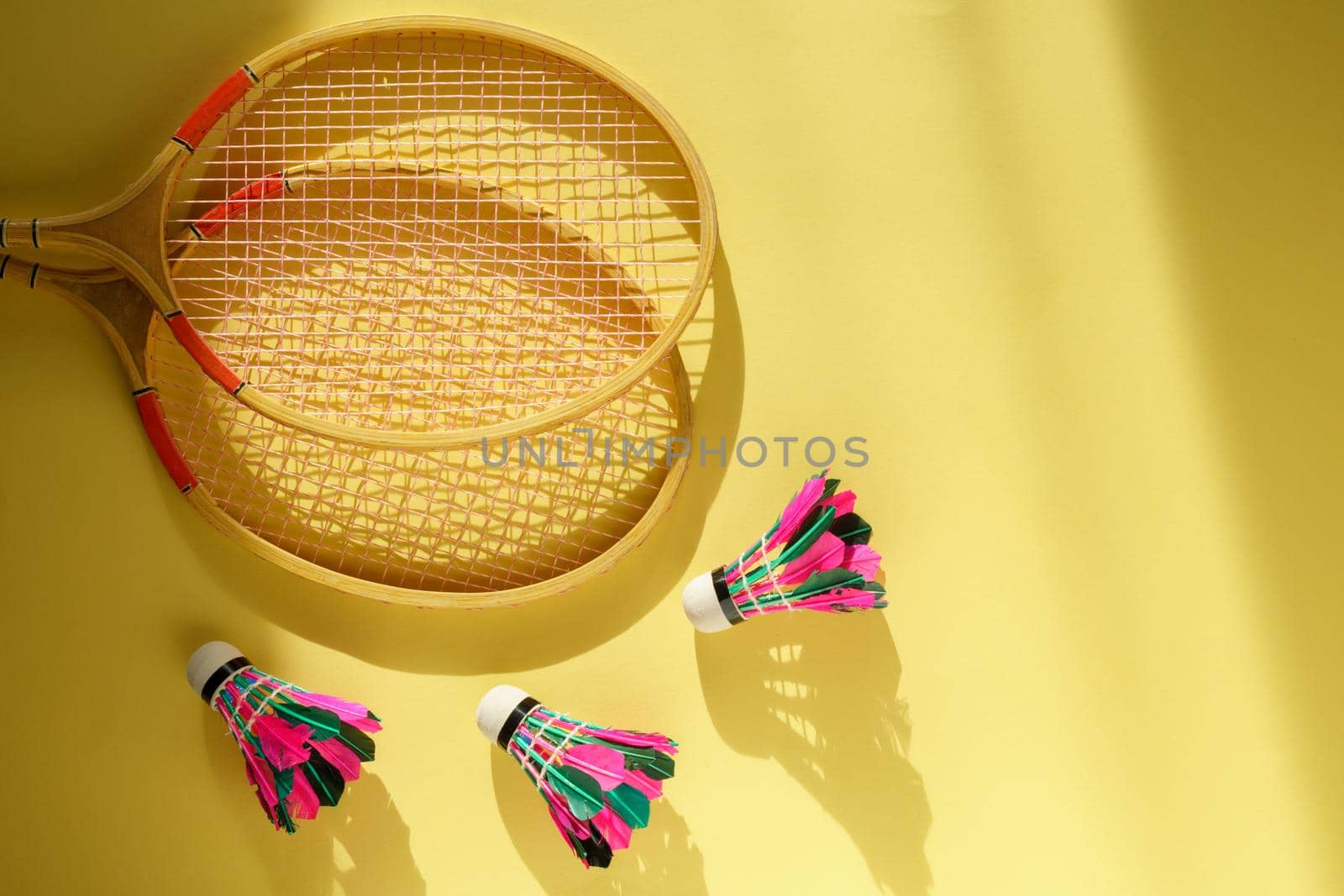 Shuttlecock and racket for playing badminton on a yellow background. Concept summer