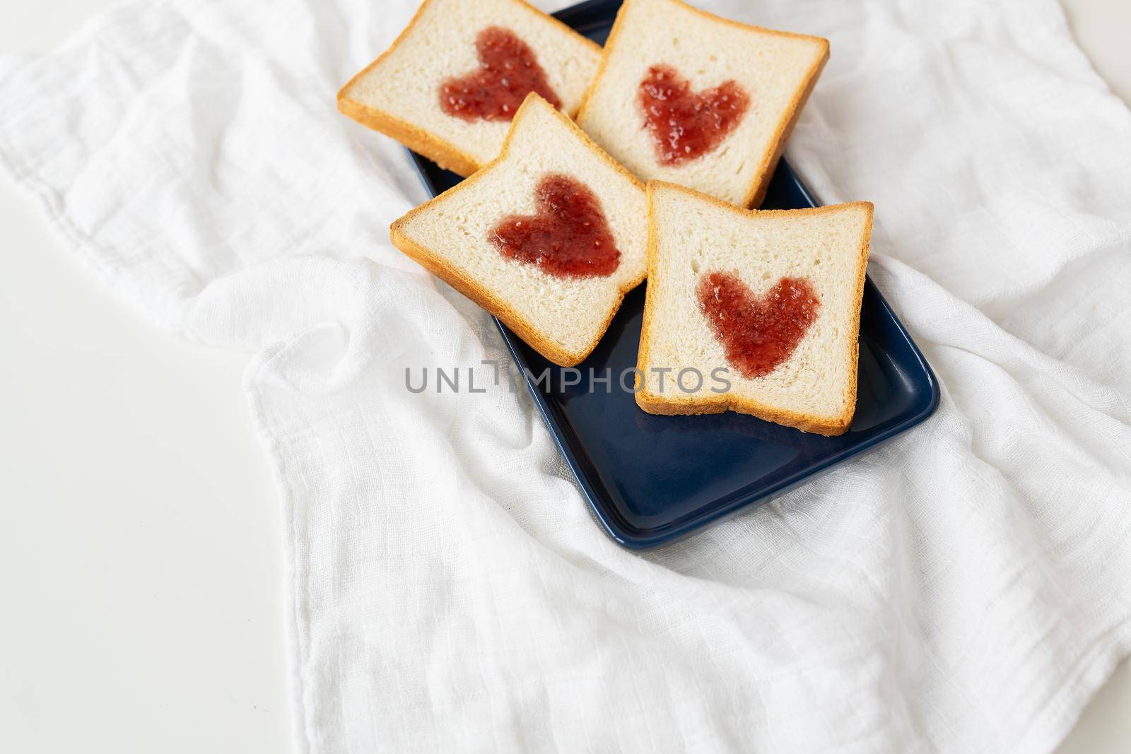 Toast on which the heart is made of jam. Surprise breakfast concept in bed. Romance for St. Valentine's Day, a place for an inscription