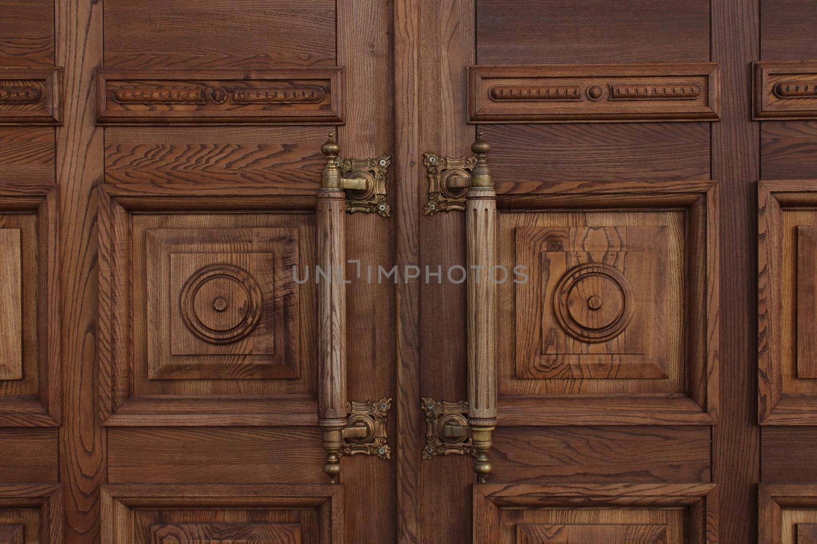 Antique massive wooden doors with large handles close-up. Ancient architecture.