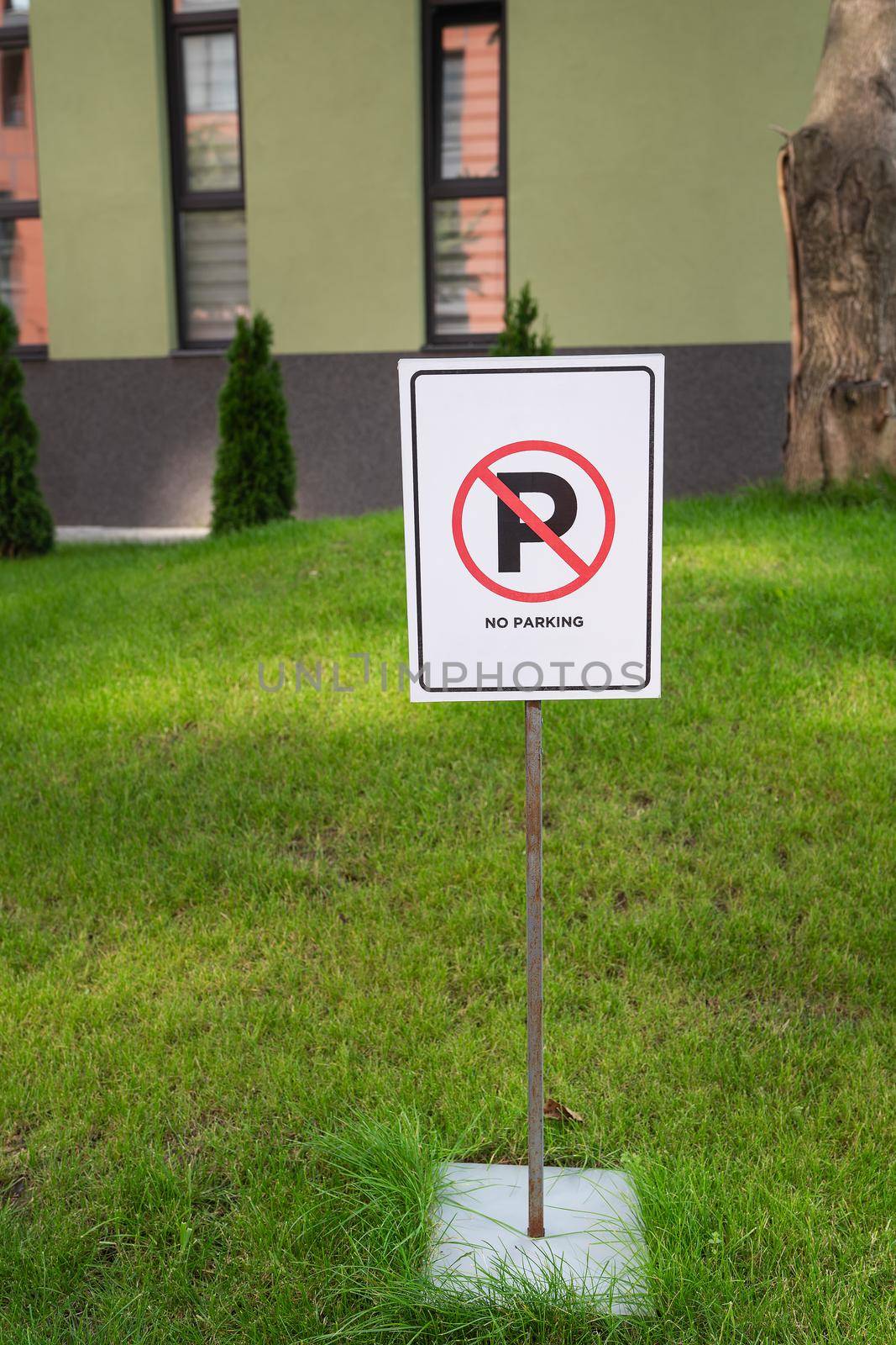 No parking sign board on green lawn stand near the house