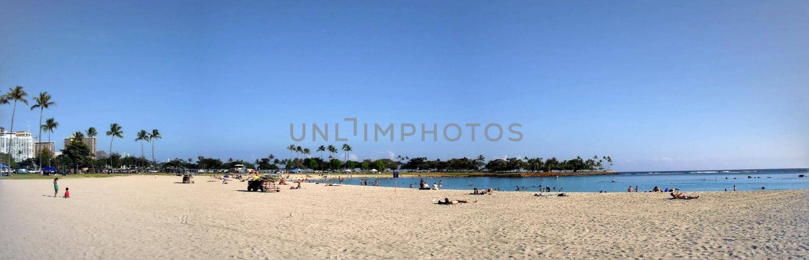 Honolulu - June 4, 2009:  Ala Moana Beach with people hanging out and swimming in the water on a beautiful day.  Panoramic