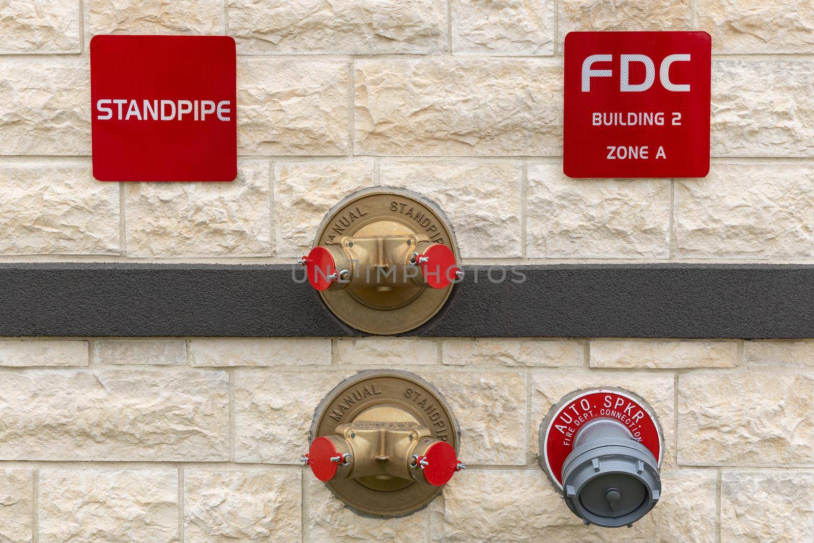 Manual standpipes, automatic sprinkler fire department connection, red signs with inscriptions on the wall of building. by Khosro1