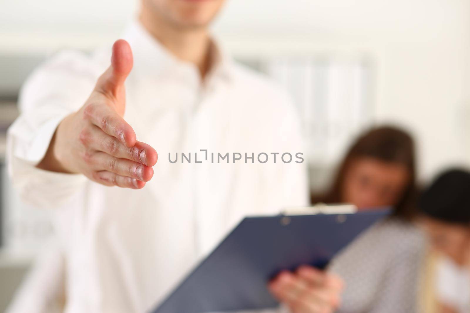 Business man intern with clipboard shaking hands. Business greeting and handshake concept