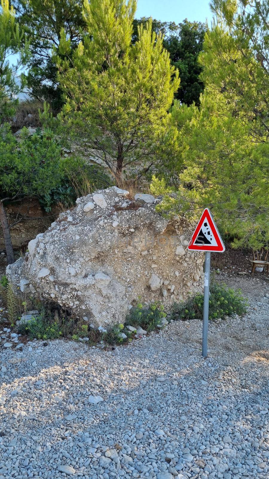 Attention sign for rock fall. Attention sign Falling rocks. Biokovo Mountain Nature park and trees from Makarska Riviera-Biokovo, Dalmatia, Croatia, Europe by anytka