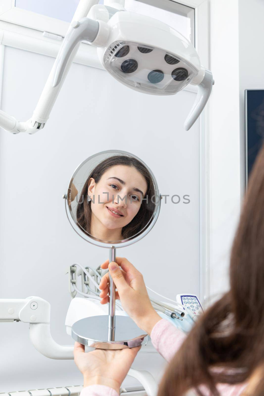 Young woman looking in a mirror after a dental procedure