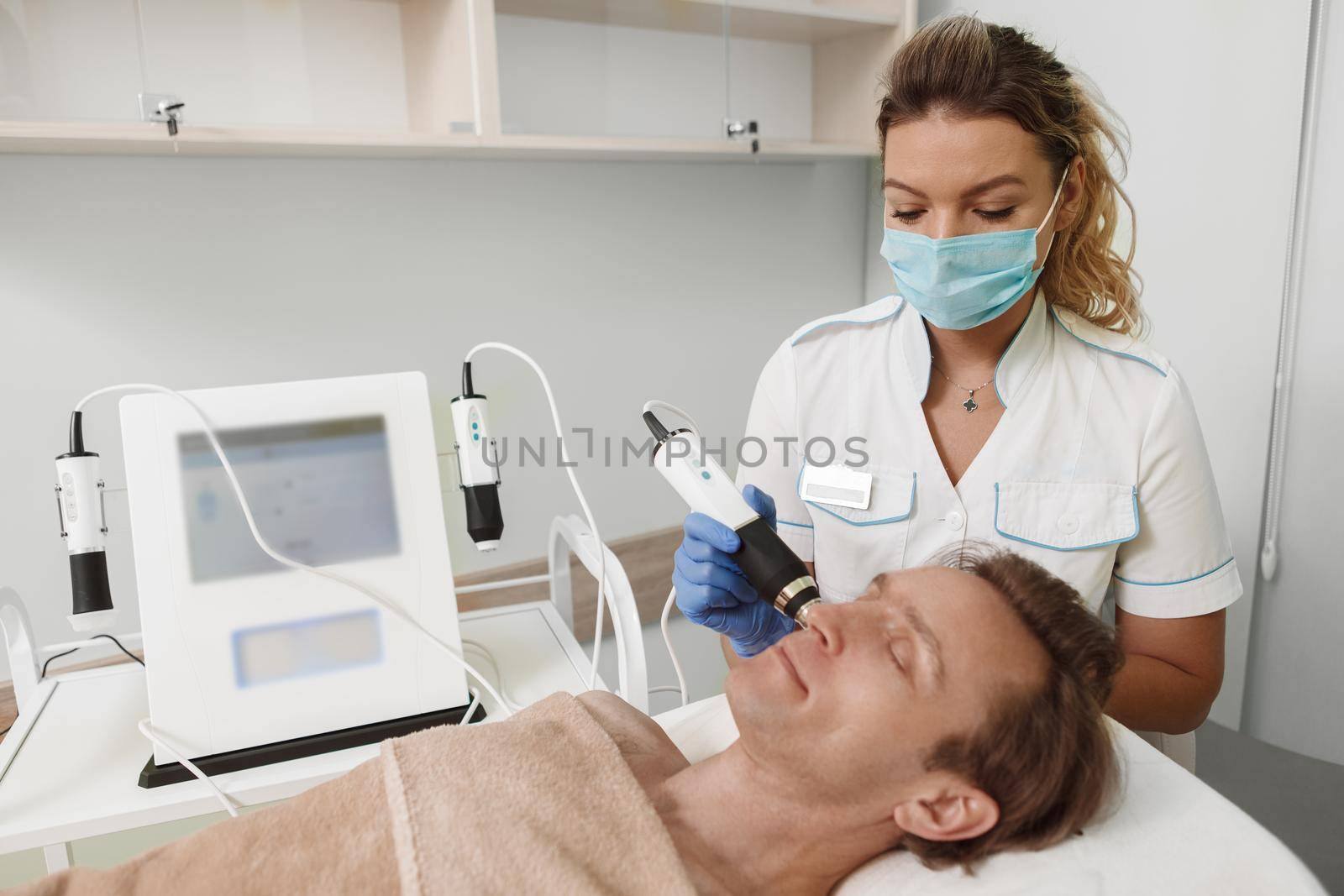 Professional cosmetologist working during pandemic, wearing medical face mask at her beauty clinic