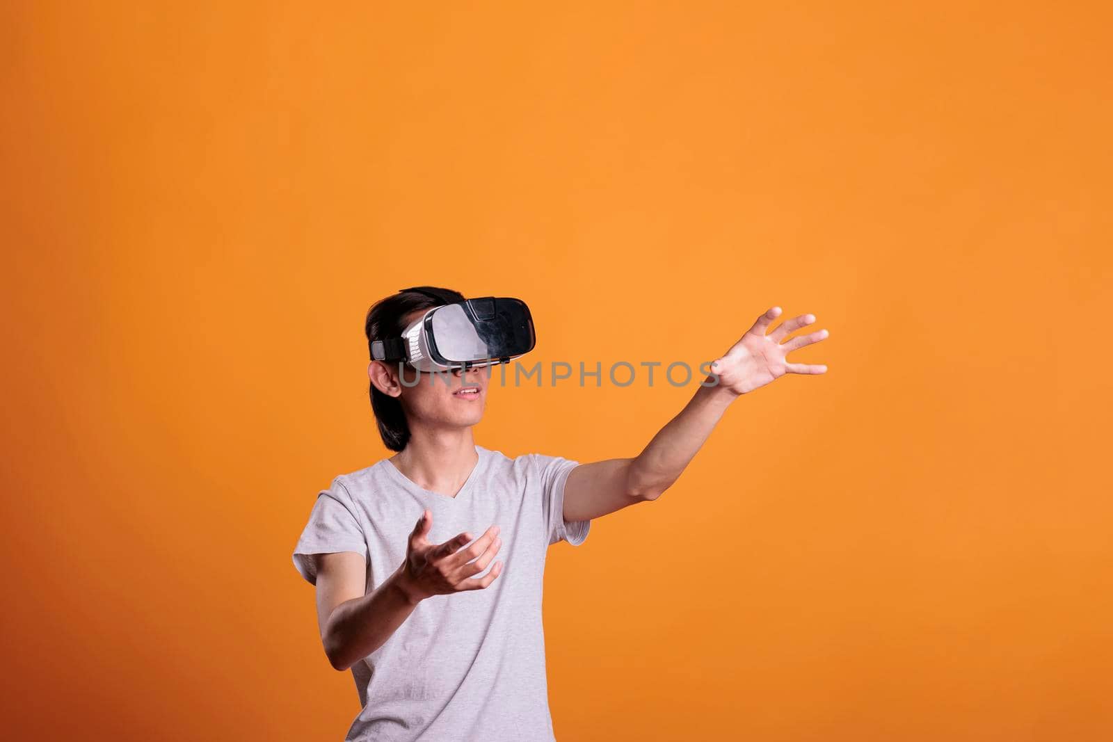 Man playing virtual reality games in vr goggles, exploring metaverse. Person wearing ar headset enjoying videogames, simulation experience, touching objects in cyberspace