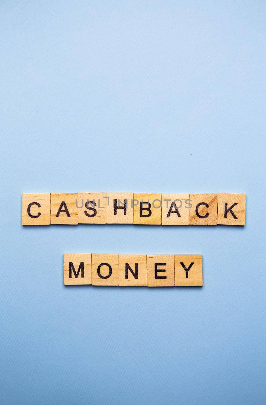 Finance concept. On a blue surface, wooden cubes with the inscription cashback money. Vertical photo