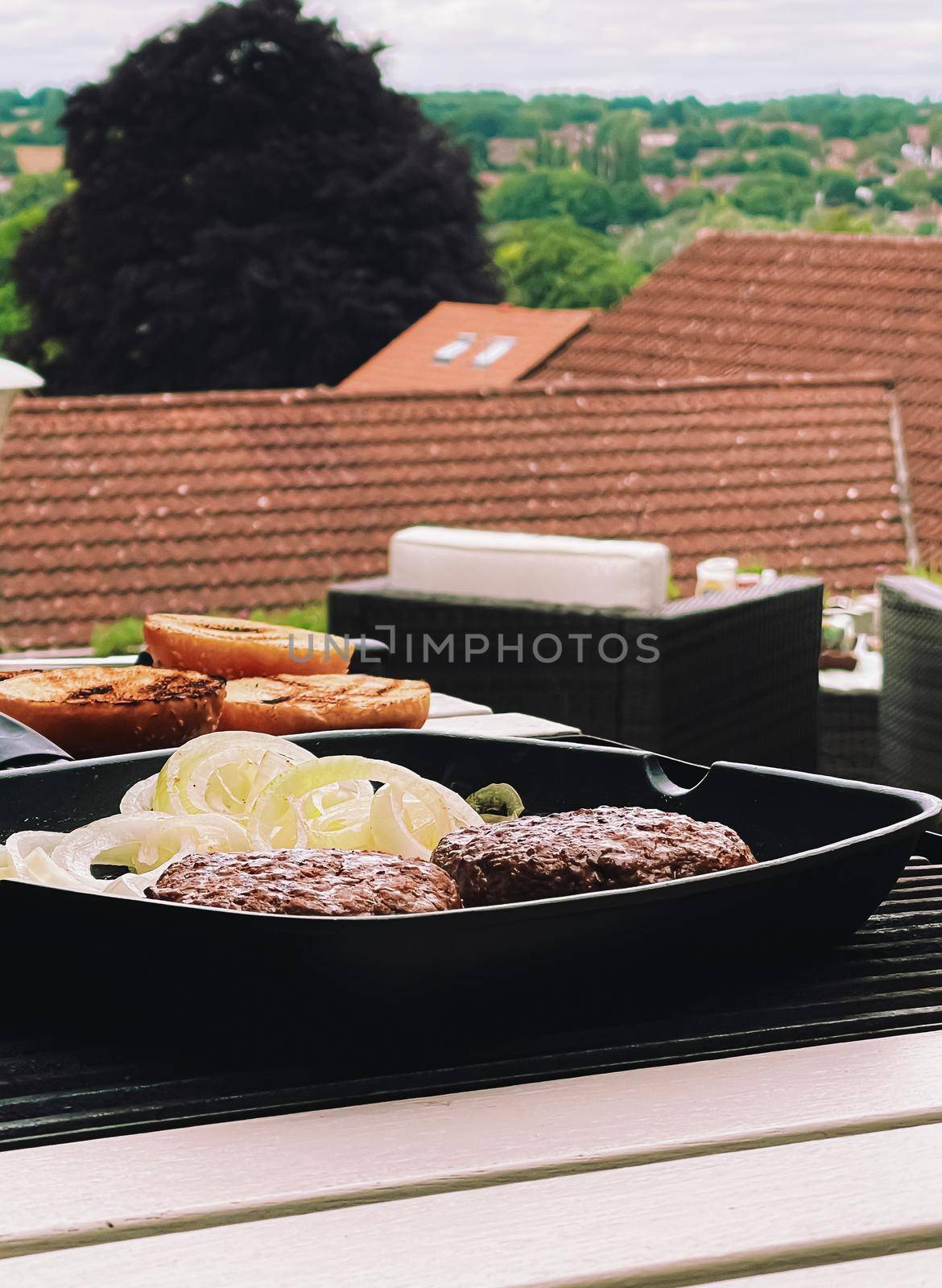 Cooking minced beef burger on cast iron grill skillet outdoors, red meat on frying pan, grilling food in the garden, English countryside living by Anneleven