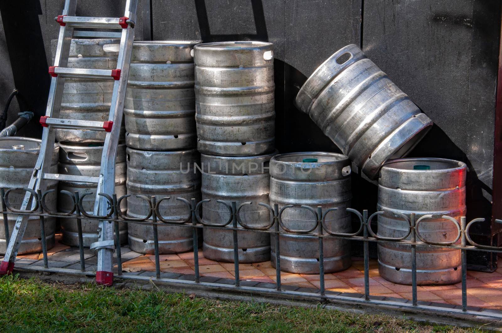 Stack of beer Kegs waiting in a bar. Beer stainless steel barrels stored in the back of a pub. Getting ready for fun