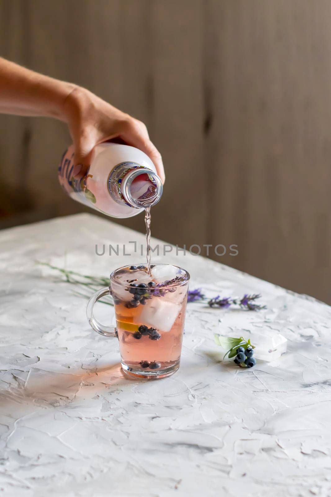 cold refreshing tea with blueberry, lime and lavender on a hot summer day on a wooden table. High quality photo