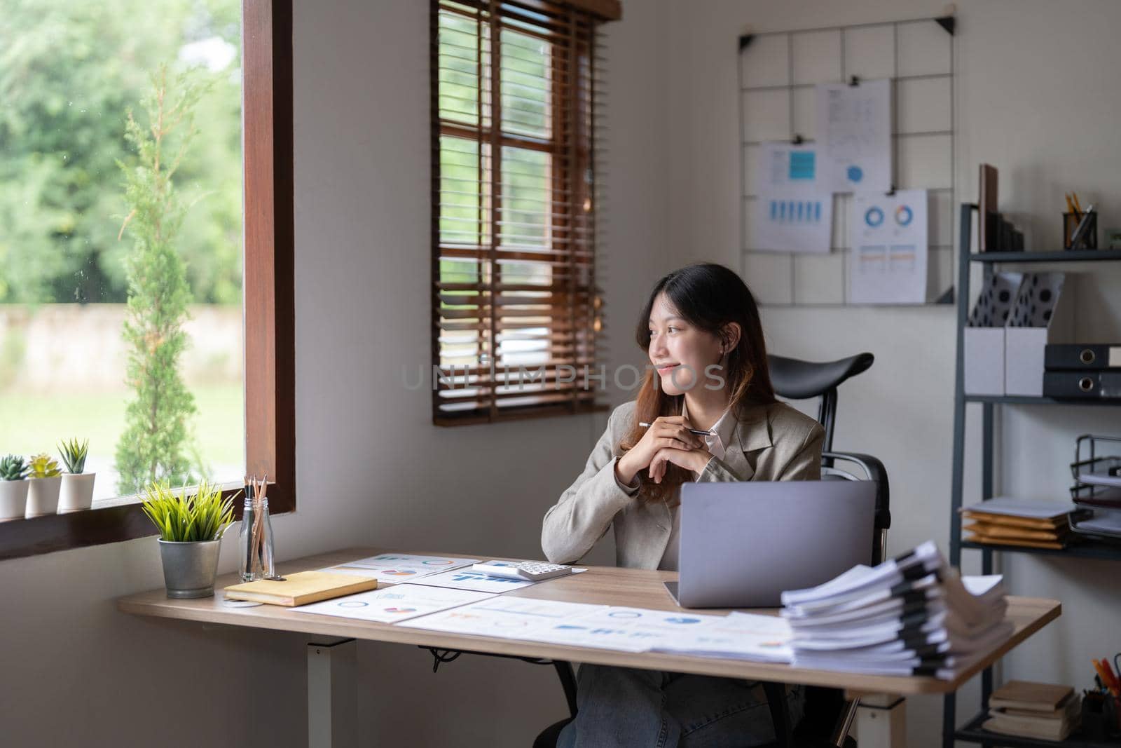 Attractive business asian woman working in office with documents. looking outside