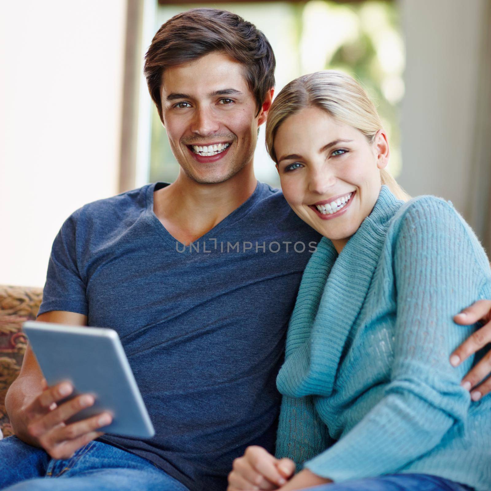 Wireless bliss. a happy young couple using a digital tablet together on the sofa at home. by YuriArcurs